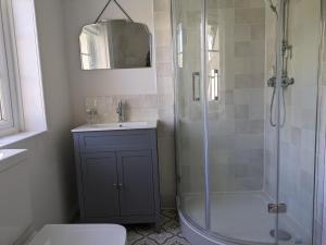 a bathroom with a shower and a sink and a toilet at Fig Tree Cottage - Corfe Castle in Corfe Castle