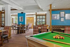 a pool table in a restaurant with tables and chairs at Sparrow Hotel in Ansty