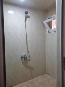 a shower stall with a shower head on a wall at Lukas guest haose in K'obulet'i