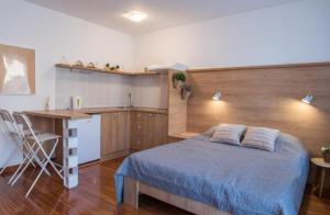 Un dormitorio con una cama y un escritorio y una cocina. en Dvoristance, en Vrnjačka Banja