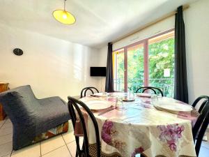 a dining room with a table and chairs and a window at Annexe Boullée Appartement 2 - Thermes Neyras les Bains in Meyras