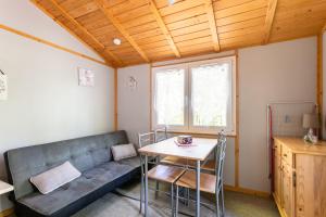 a living room with a couch and a table at Camping Au Bois Dormant in Chauffour-sur-Vell