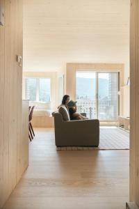a woman sitting on a couch in a living room at Volume Nord in Stoneham