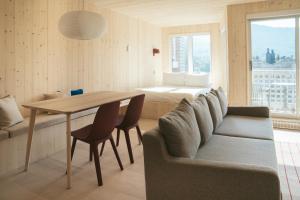 ein Wohnzimmer mit einem Tisch, einer Couch und einem Bett in der Unterkunft Volume Nord - Loft de montagne in Stoneham + 24 Fotos