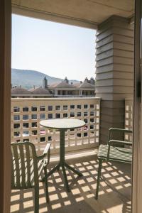 eine Terrasse mit Tisch und Stühlen auf einem Balkon in der Unterkunft Volume Nord - Loft de montagne in Stoneham