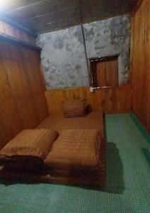 a bedroom with two beds in a wooden room at Triệu hoan homestay nhà sàn cổ in Dam Thuy