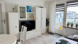 a living room with a white entertainment center with a tv at MEERzeit in Westerland (Sylt)