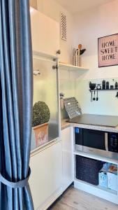 a kitchen with a curtain next to a microwave at MEERzeit in Westerland (Sylt)