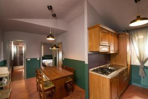 a kitchen with wooden cabinets and a table and a dining room at Il Ciocco Cottages in Castelvecchio Pascoli