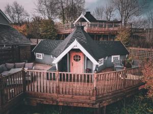 a house with a porch with a wooden deck at 1 Romantic cabin for two with outdoor bath and Sauna! in Pont Sticill