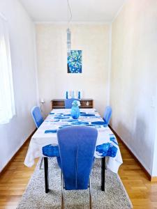a dining room with a blue table and chairs at Casa le palme -Montagnola in Collina d'Oro +16 photos