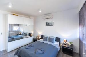 a bedroom with a blue bed and a mirror at Gems of Budapest - Onyx Suite in Budapest