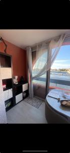 a bedroom with a bed and a large window at Appartement Marina in Le Barcarès
