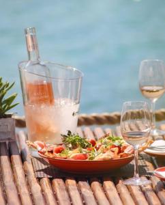 a table with a plate of food and a glass of wine at Royal Antibes - Luxury Hotel, Résidence, Beach & Spa in Antibes