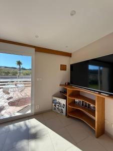 a living room with a flat screen tv and a large window at Domaine de LA GRIME in Lias