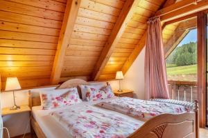 a bed in a room with a wooden ceiling at Ferienwohnung Weiherblick in Hornberg