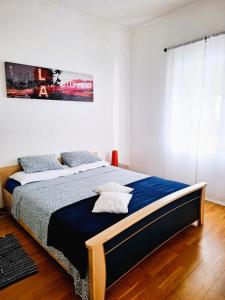 a bedroom with a bed with a blue comforter at Casa le palme -Montagnola in Collina d'Oro