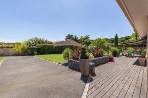 a courtyard with a wooden walkway with cacti and plants at Villa Garonne- Piscine Confort proche Toulouse in Saubens