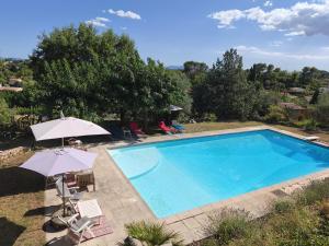 a large swimming pool with umbrellas and chairs at Chambres d'hôtes de charme La Joséline in Flayosc +48 photos