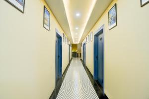 einen Flur mit blauen Türen und weißem Fliesenboden in der Unterkunft Hotel O Palm Inn Durgapura Railway Station in Jaipur