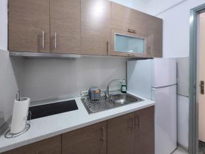 a small kitchen with a sink and a refrigerator at EVGENIA Apartments by SDR in Paralia Katerinis