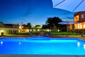 una piscina en un patio trasero por la noche en Apartments Bonex, en Privlaka