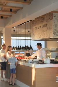 a group of people standing in a kitchen preparing food at Lyttos Beach in Hersonissos