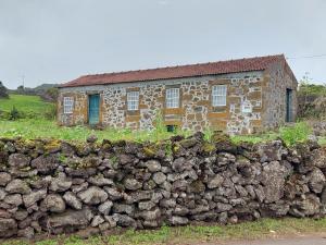 PiedadeAdega do capitao的石墙后面的一座古老的石头房子