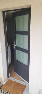 a black door with a window in a house at Appart T2 indépendant in Dammarie-lès-Lys