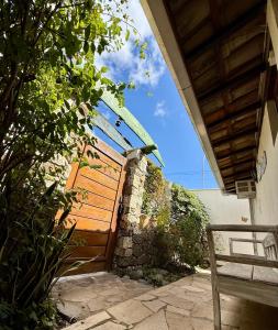 a wooden gate to a building with a bench at Recanto de Gaia in Ilhabela