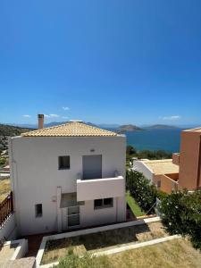 a white house with a view of the ocean at Casa MareLuna in Egina