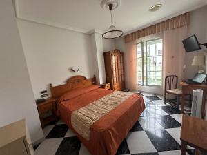 a bedroom with a bed and a desk and a window at Hotel Mediante in Ribadeo