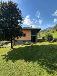 a house with a tree in a yard at Villa Magnolia Oliveti relax e privacy con panorama mozzafiato in Crosano