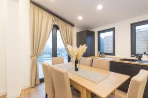 a kitchen and dining room with a wooden table and chairs at SUNNYHOME Chalet, Neunburg vorm Wald in Neunburg vorm Wald +16 photos