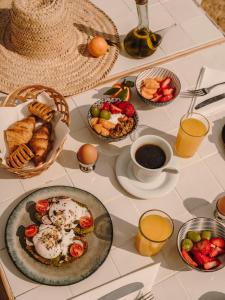 a table topped with plates of food and cups of coffee at Ibara Ibiza Hotel Boutique in Es Cana +72 photos