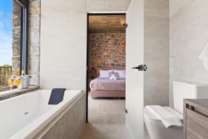 a bathroom with a bath tub and a bedroom at Petres Luxury Villas with heated private pool in Agia Galini