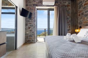 a bedroom with a large bed and a large window at Petres Luxury Villas with heated private pool in Agia Galini