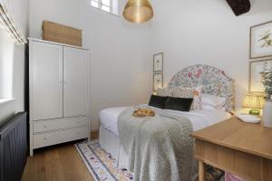 Schlafzimmer mit einem Bett mit einem Tisch und einem Schreibtisch in der Unterkunft Little Bird Cottage in Bibury