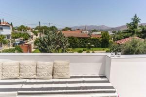a balcony with pillows and a view of a city at Marry House in Khoustoulianá