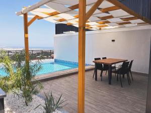 a patio with a table and chairs and a pool at Villa Zena Demre in Demre