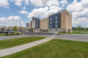 a large building on a street with a green lawn at Candlewood Suites - Detroit - Auburn Hills by IHG in Auburn Hills
