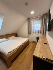 a bedroom with a bed and a flat screen tv at Chata Vojtek in Terchová