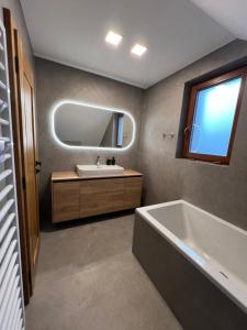 a bathroom with a tub and a sink and a mirror at Chata Vojtek in Terchová +21 photos