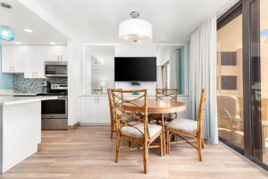 a kitchen with a table and chairs and a tv at Costa Del Sol Resort in Fort Lauderdale +6 photos
