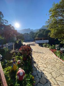 a stone walkway with flowers in a garden at Pousada do Bezerra in Alto Caparao