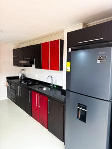 a kitchen with a refrigerator and red cabinets at Casa Encanto Para Grupos y Familias in Bucaramanga +12 photos