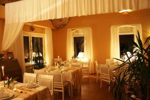 a dining room with white tables and chairs and windows at Landhaus Martens in Bresewitz