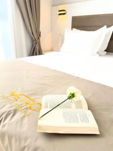 a book with a flower on top of a bed at Metro Hotel Terminal in Tirana