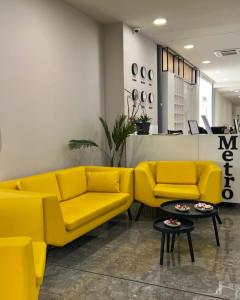 a lobby with two yellow couches and a table at Metro Hotel Terminal in Tirana