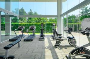 a gym with several tread machines in a large room at My Resort Huahin by Ying in Hua Hin